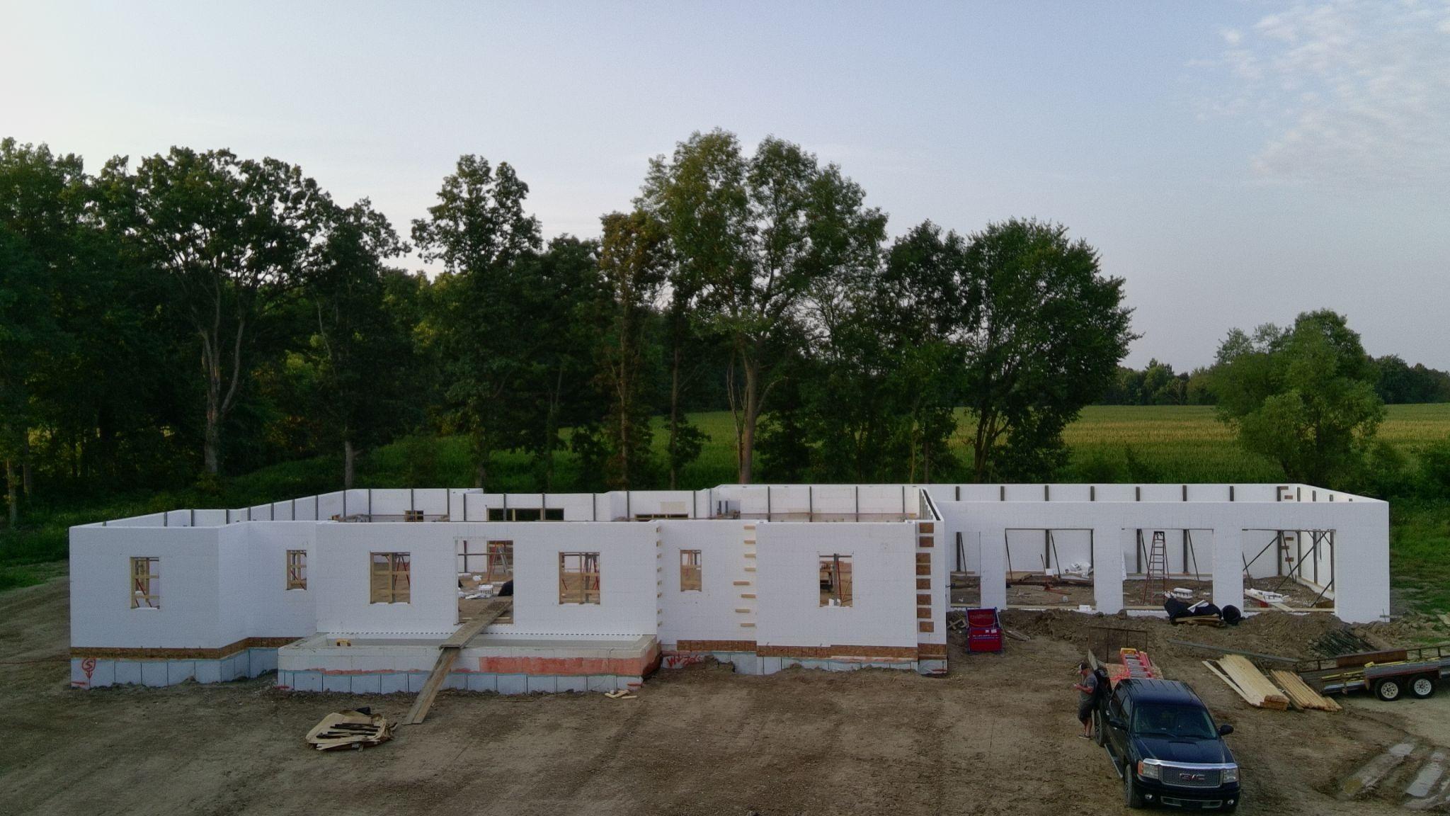 Wide view of a single-story ICF wall shell with window openings on a graded lot