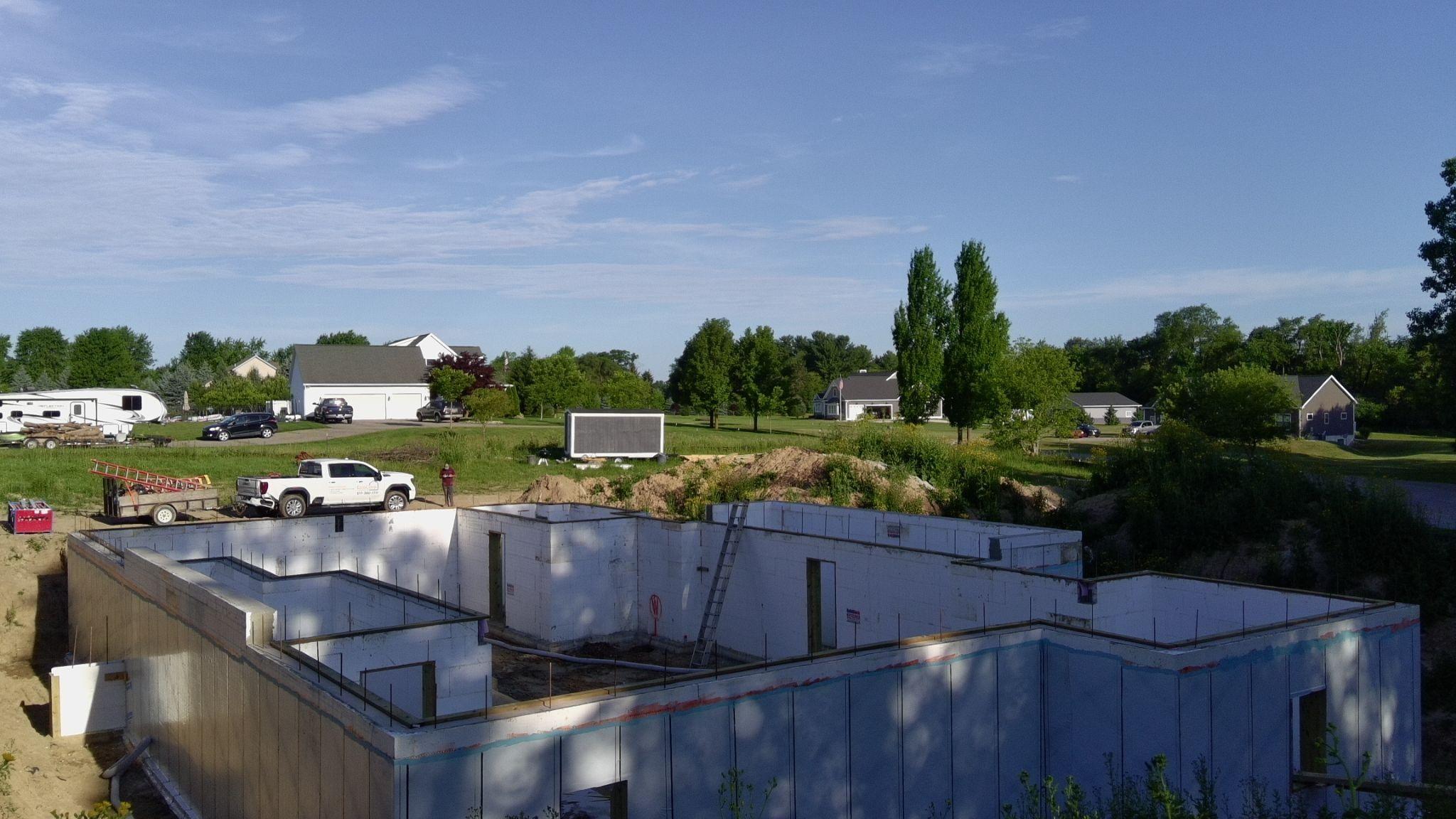 ICF foundation walls coated with a dark waterproofing membrane below grade