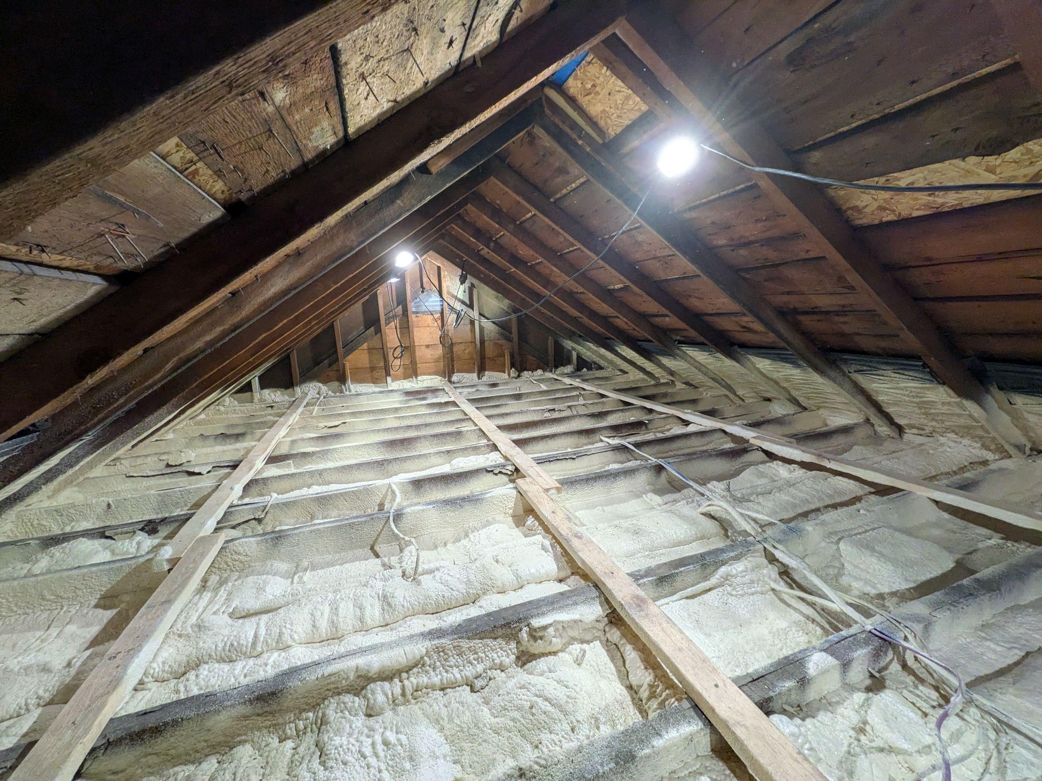 An attic with blown-in insulation between the rafters
